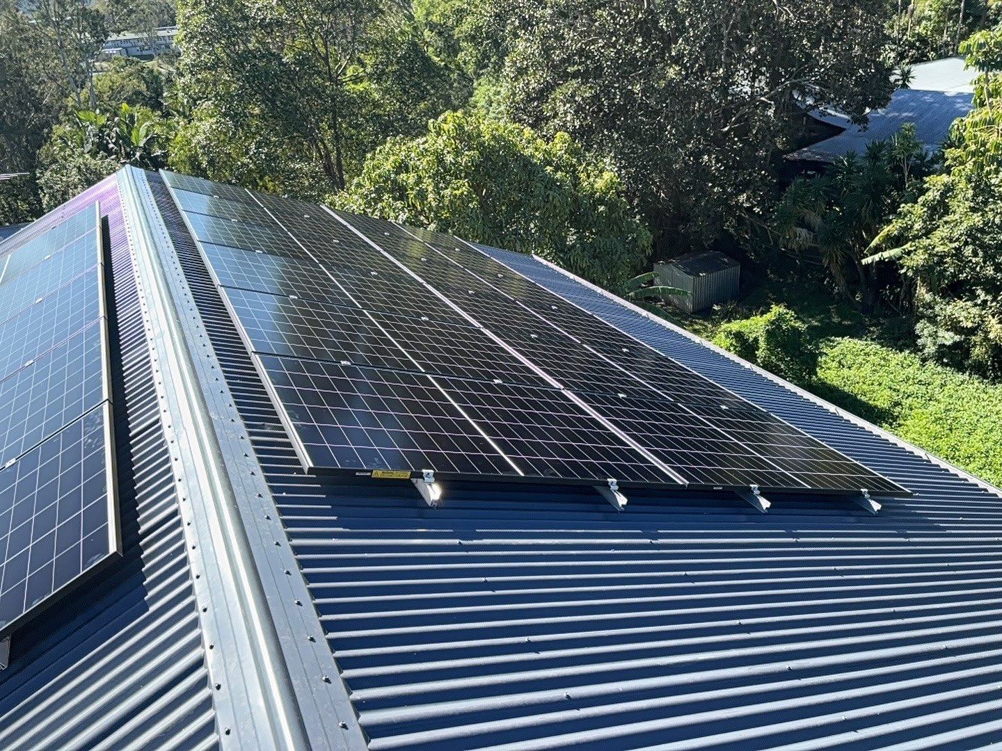 Solar array on a Coast roof surrounded by greenery